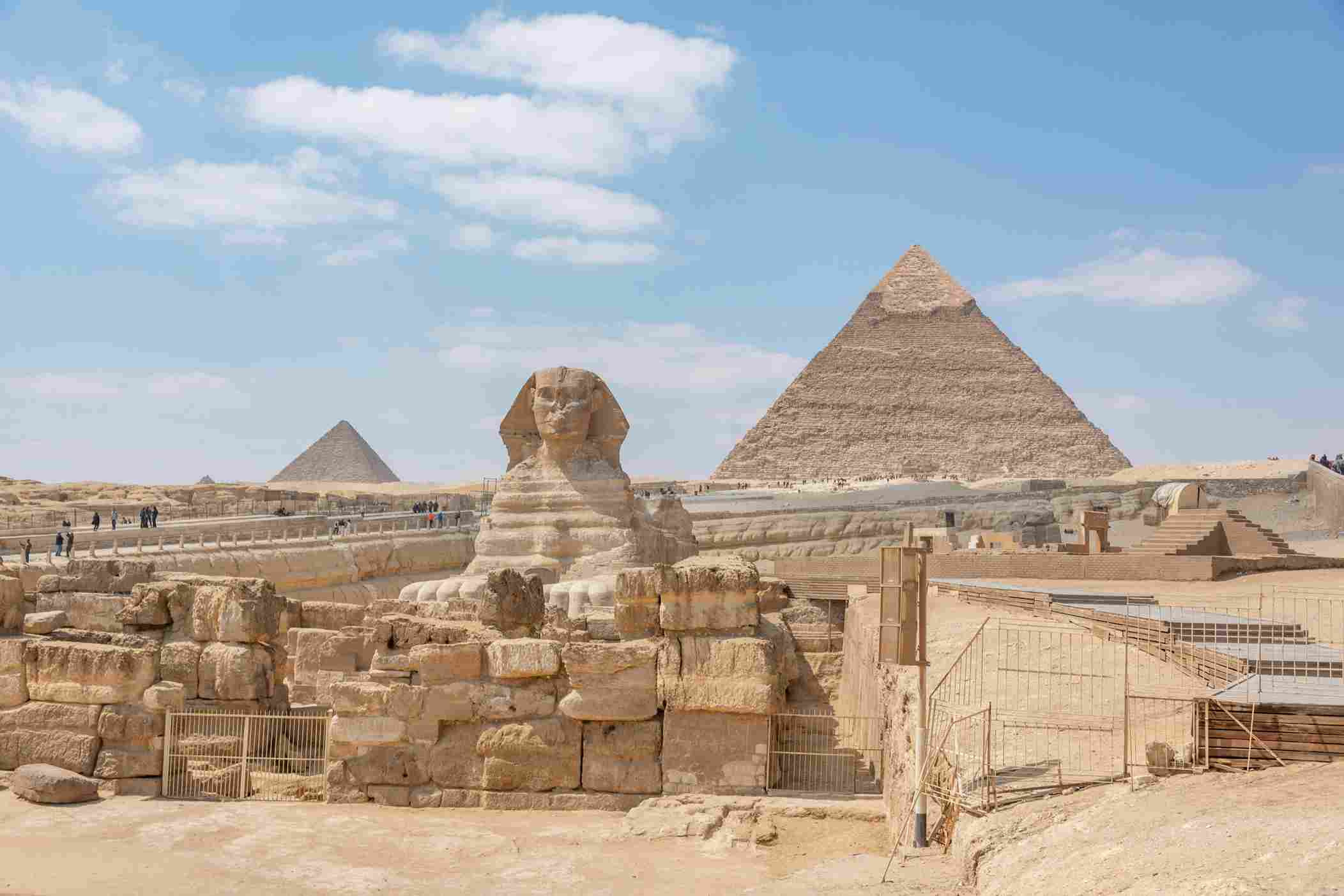Great Sphinx statue Pyramids of Giza desert sand Egypt blue sky
